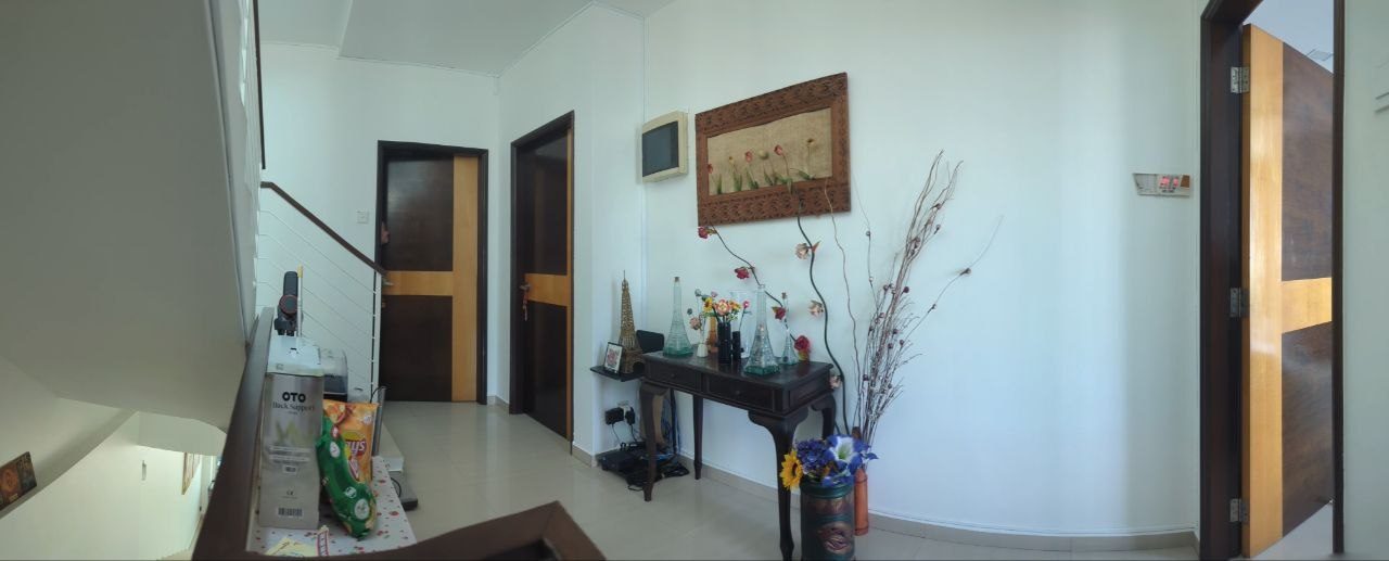 Hallway before editing, with boxes, snacks, vases and flower arrangements